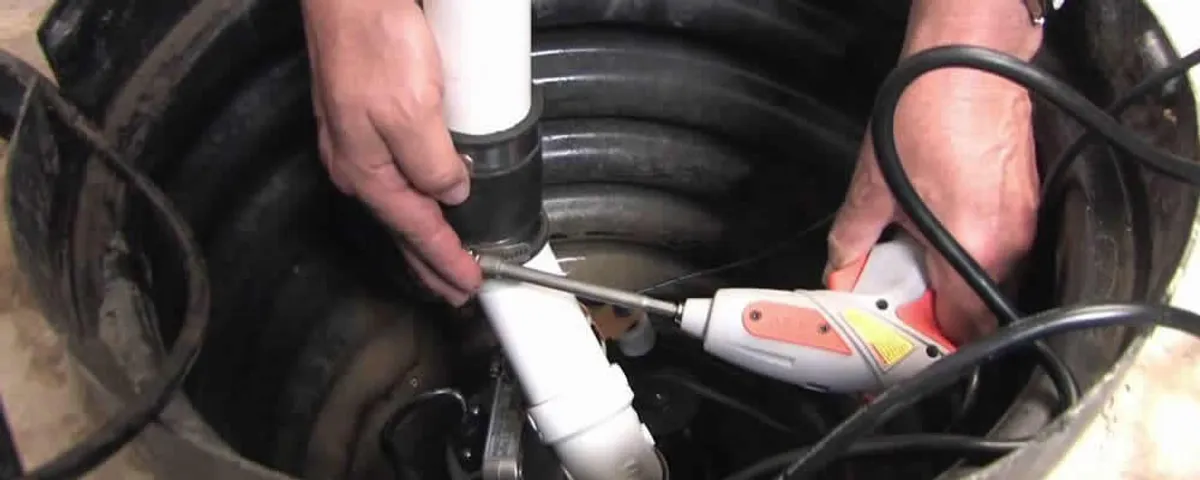 Sump pump installation technician connecting PVC discharge piping in Sacramento, CA